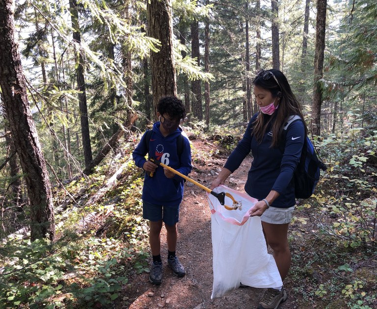Hikers picking up trash on trail. Photo by Sandy Yee