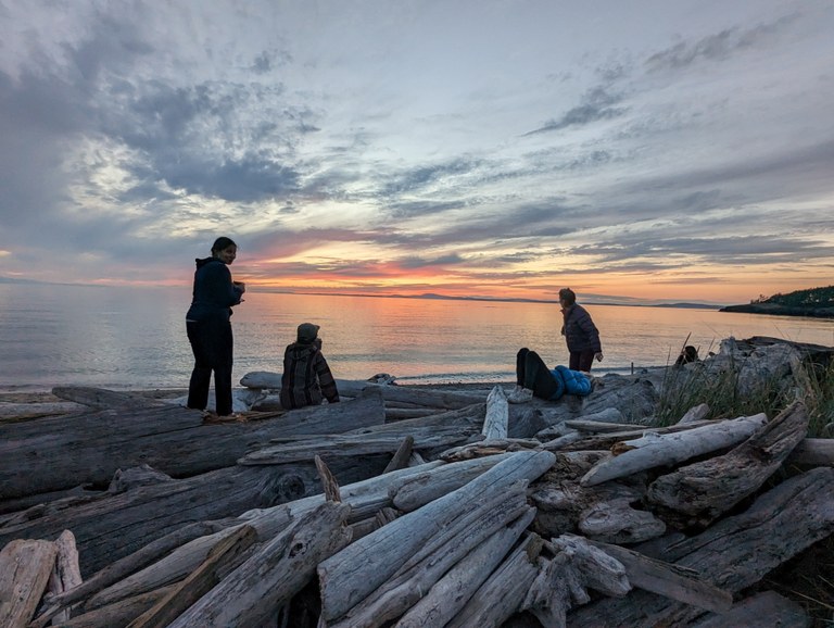 Deception Pass volunteer vacation. Photo by Karin Plagens. A group of crew members watch the sunset on the water on a volunteer vacation at Deception Pass. Photo by Karin Plagens.