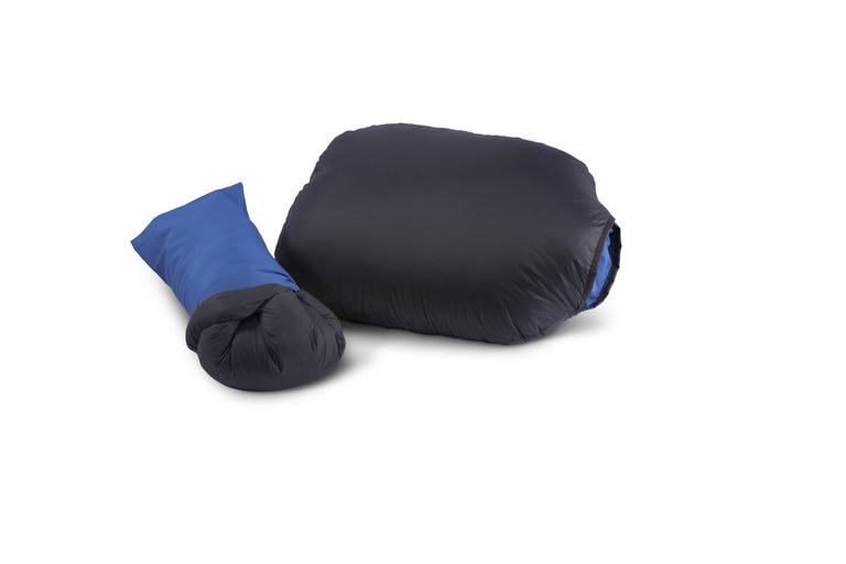 A small black down pillow with an attached blue stuff sack that can be used to store the pillow.