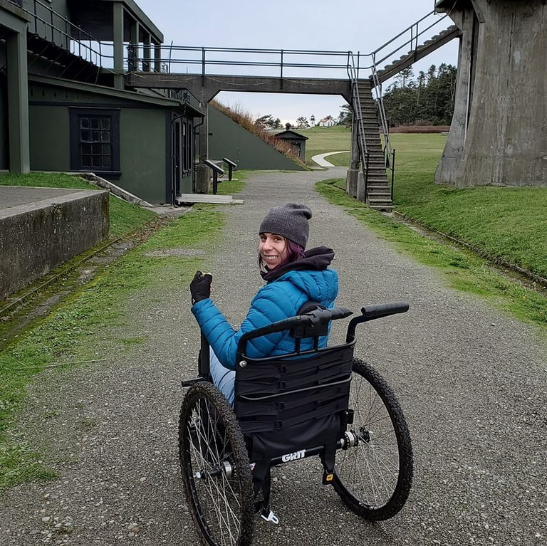 hiker in manual wheechair on wide gravel path at Fort Casey. Photo by thedirtbaguette.  hiker in manual wheechair on wide gravel path at Fort Casey. Photo by thedirtbaguette.