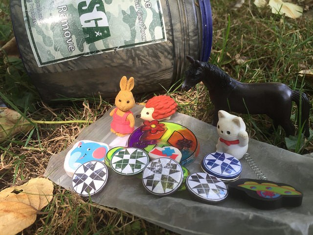 A collection of small toys outside of a geocache container. 