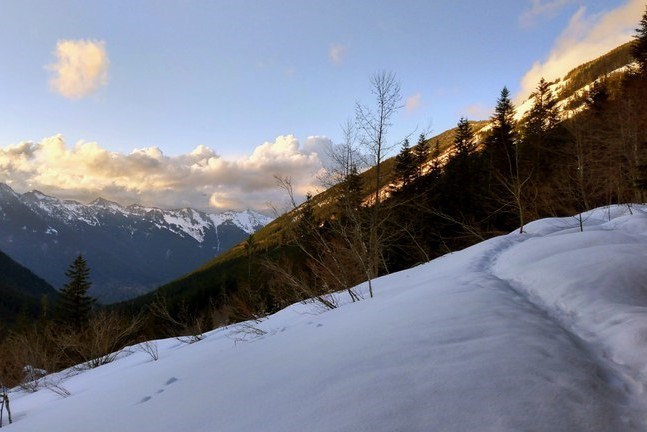 Granite Lakes and Thompson Point A snow covered trail with a worn foot path leading up it.