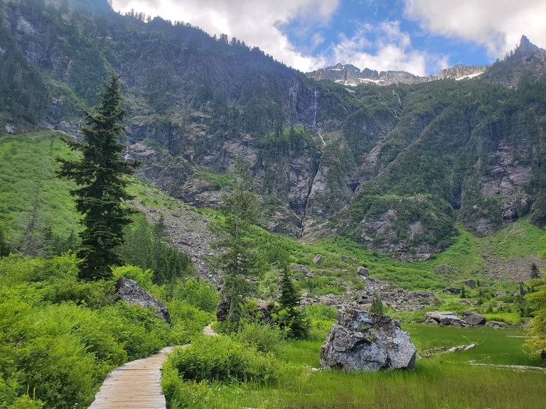 Boardwalk on the trail to Heather Lake, surrounded by moss- and brush-covered mountains. Photo by bethanyyyy.