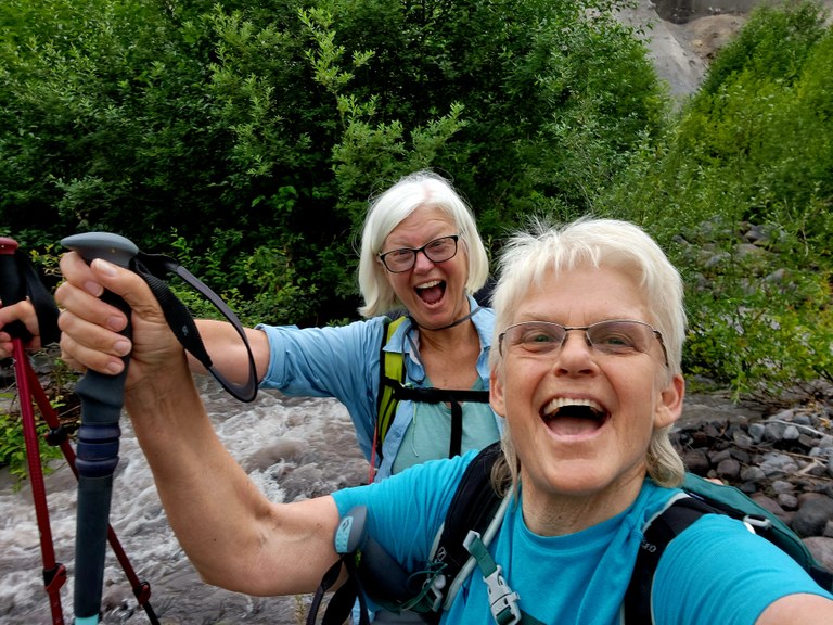 By Bonnie Rae Nguyen Two hikers smile together for a selfie.