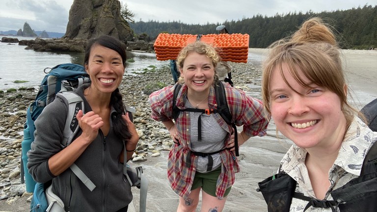 Friends. Photo by Erica Chang. Three friends smile big for a selfie on a beach backpacking trip.