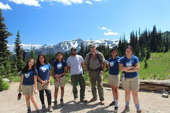Girls pose with trail bosses, Boston and Alex, after a hard day of building check-steps. Photo by Michelle Piñon