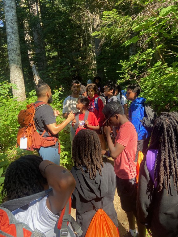 Booby speaks to a group of youth on trail.