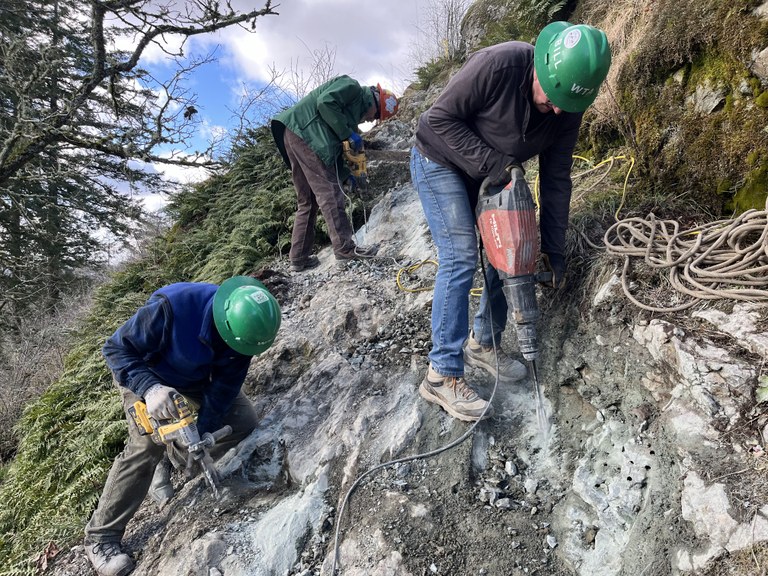 WTA volunteers use various tools to shape rock on a new route on Big Rock. 