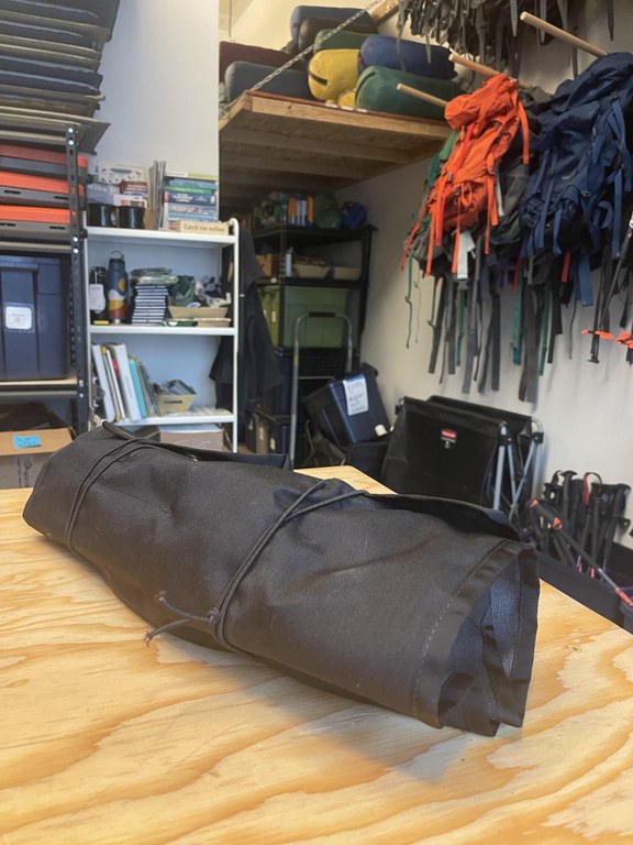 A bundle of black fabric is rolled neatly together