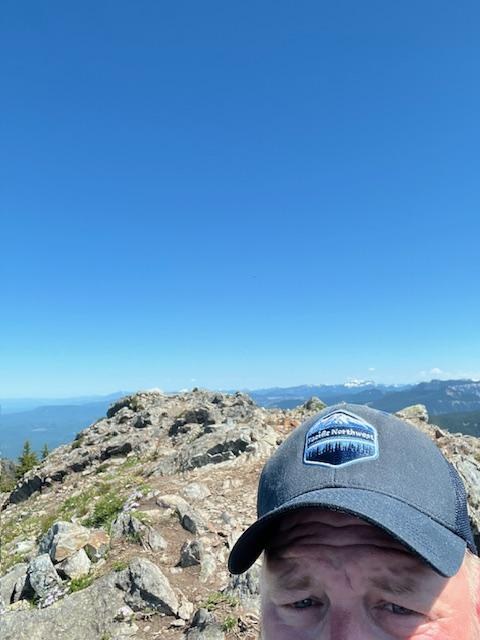 Trip reporter Seattle_Wayne with a hat standing at the top of Mount Teneriffe. Photo by trip reporter Seattle_Wayne.
