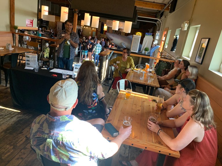 A group of staff and donors are gathered at a brewery.