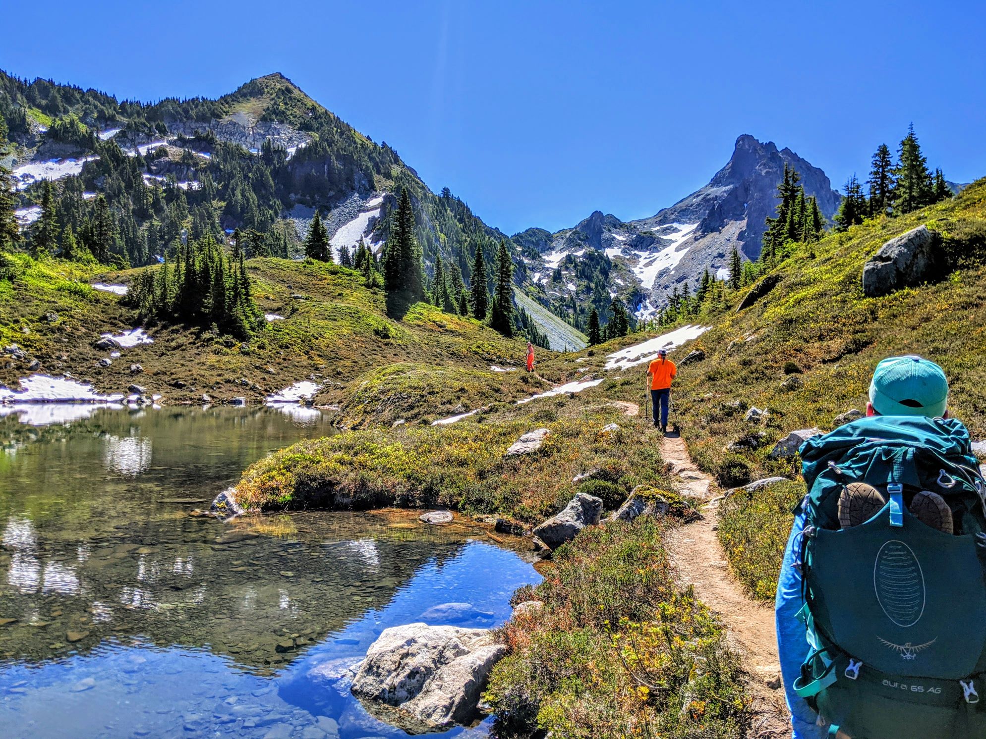 Hikers hiking at Jade Lake in the Alpine Lakes Wilderness on a sunny day. Photo by Alicia Mau.