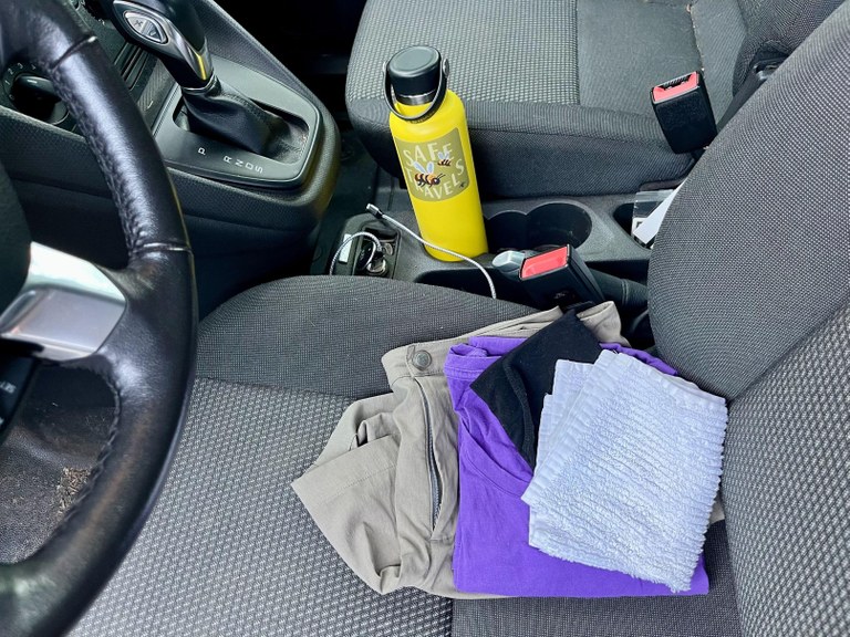 A change of clothes and a water boittle in the front seat of a car. Photo by Jenn Seva.