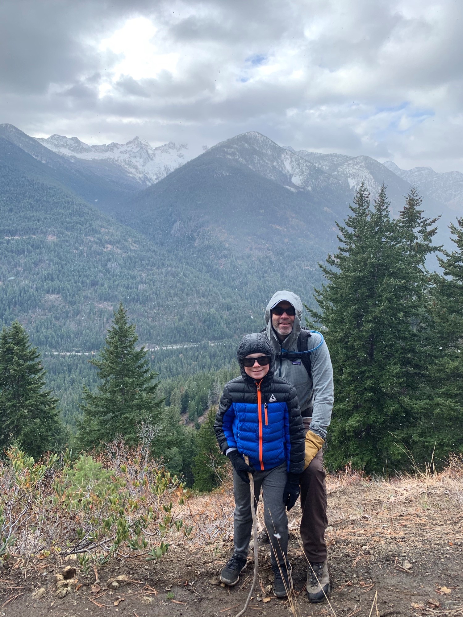 Jon and his son with mountains and clouds in the background. 