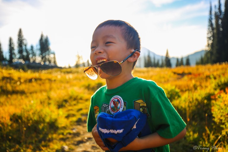 A close up of a child's smiling face on trail.