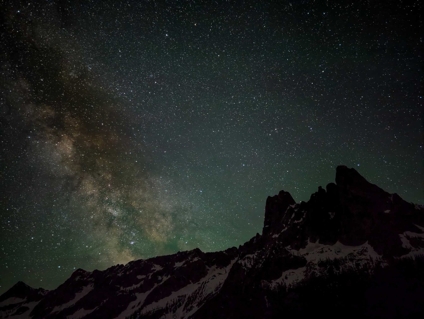 A star-filled sky above the jagged peak of Liberty Bell