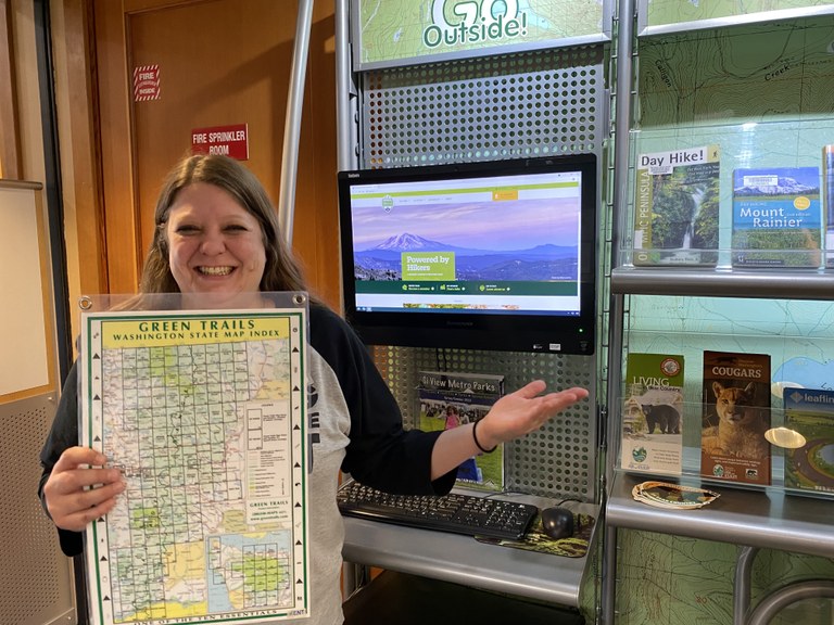 Library Kiosk A library employee in North Bend stands in front of the kiosk with information on hiking in Washington.