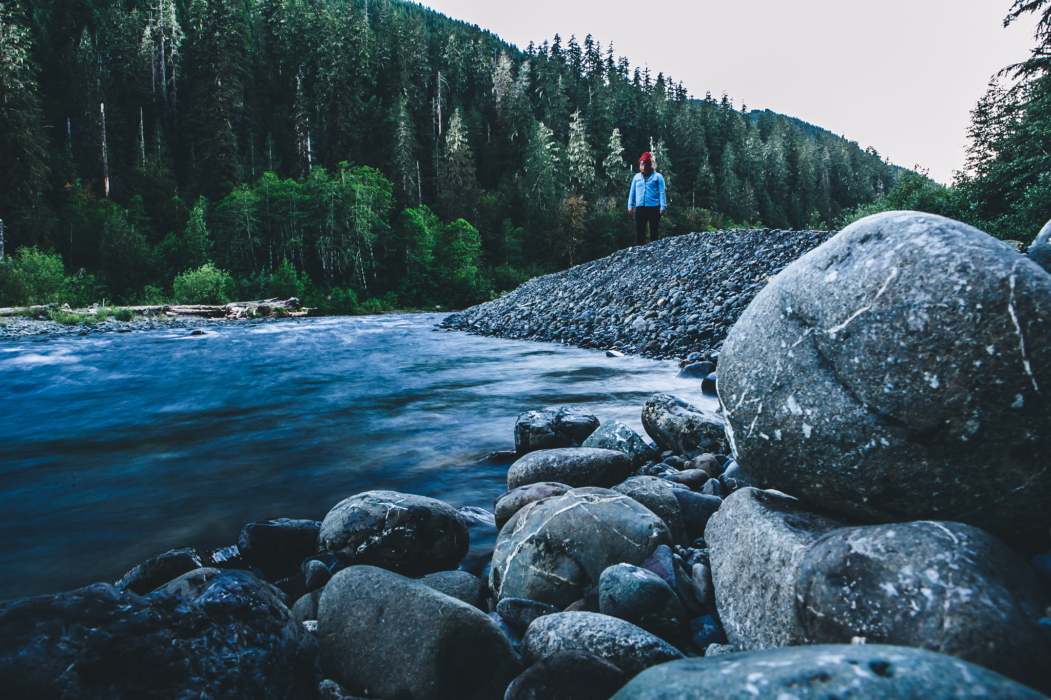 A hiker stands next to the Lower South Fork Skokomish River on a dusk hike in fall. Photo by Rebecca Cooper