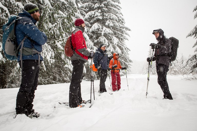 A group of snowshoers, wearing winter gear, including OR gaiters. 