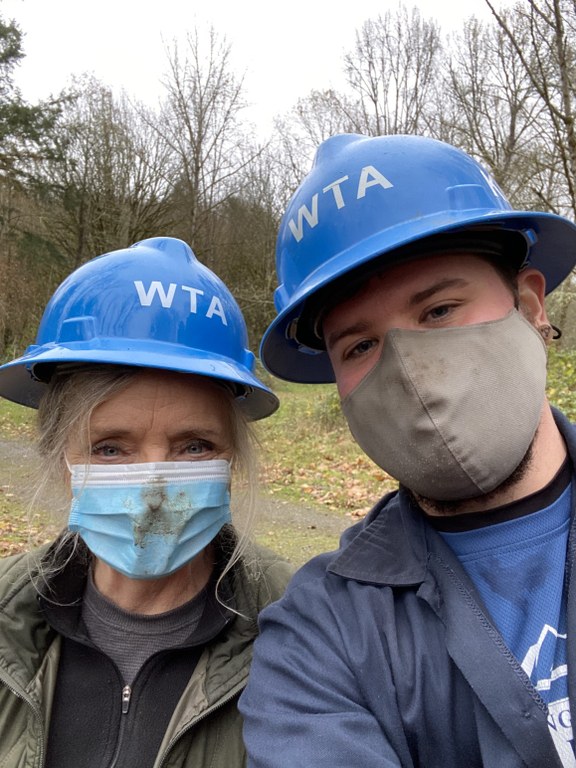 Two crew leaders, wearing blue WTA hard hats and face masks, pose for a selfie. 
