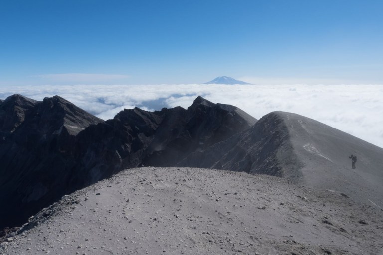 Mount St. Helens summit. Photo by Bill Hinsee. Hiker climbing up to the Mount St. Helens summit/crater. Photo by Bill Hinsee.