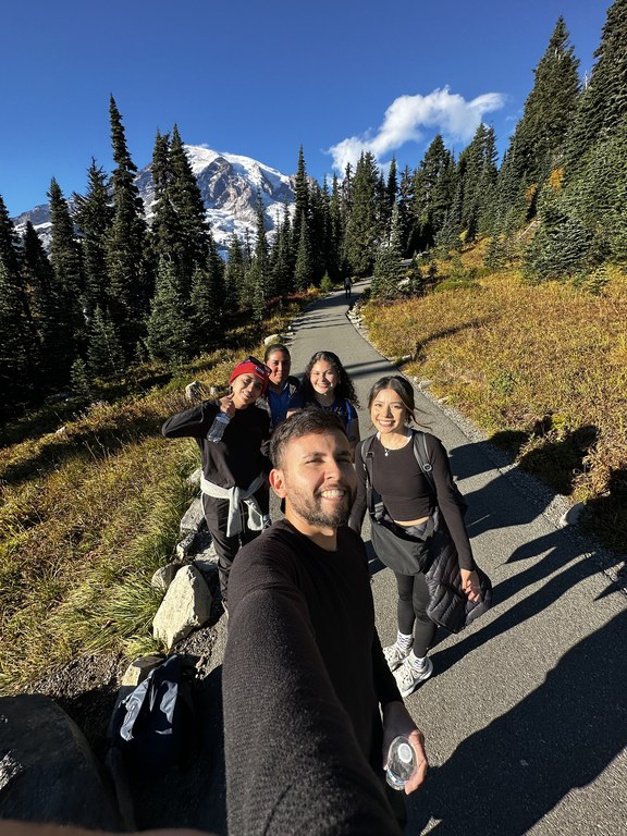 A group of hikers take a selfie in the fall with Mount Rainier in the background. 