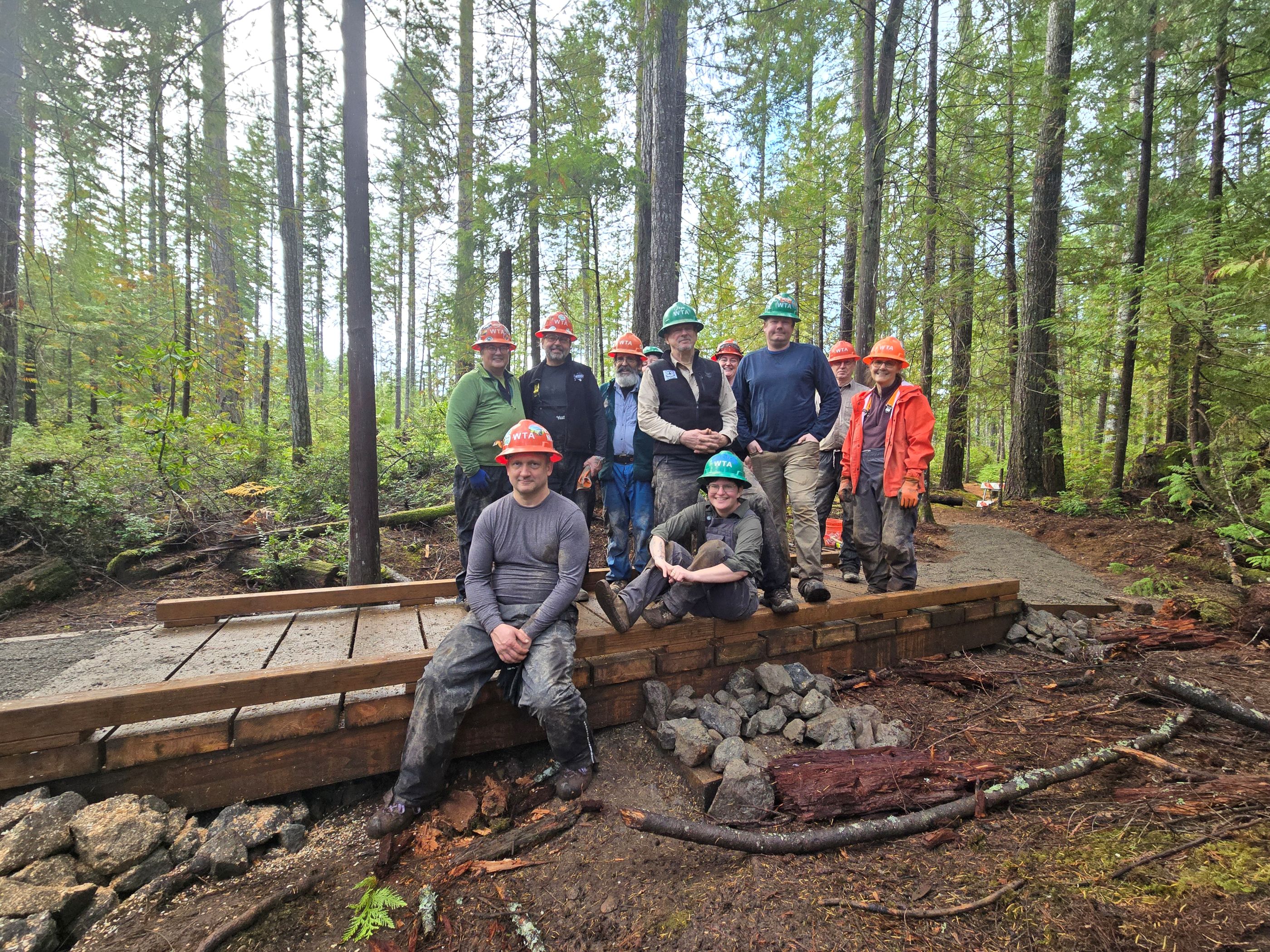 A WTA trail crew poses, smiling, at a newly-built puncheon at Newberry Hill Heritage Park. Photo by crew leader Paul Boronow. 
