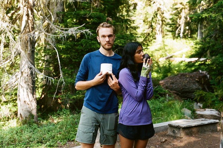 Hikers with toilet paper and an avocado. Photo by Nishi Sharma Two hikers pose in the forest with toilet paper and an avocado. The woman holding the avocado is kissing it, the one holding the toilet paper looks very serious.