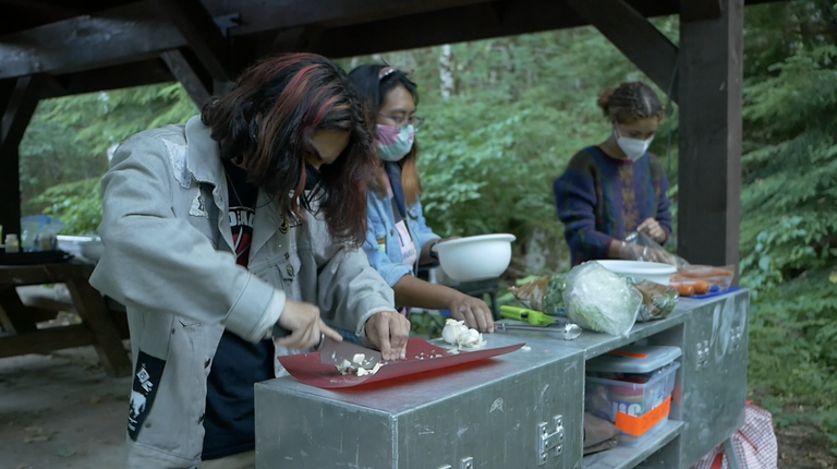 Meal prep by Cole Hanych Teens prep a meal together in a backcountry kitchen.