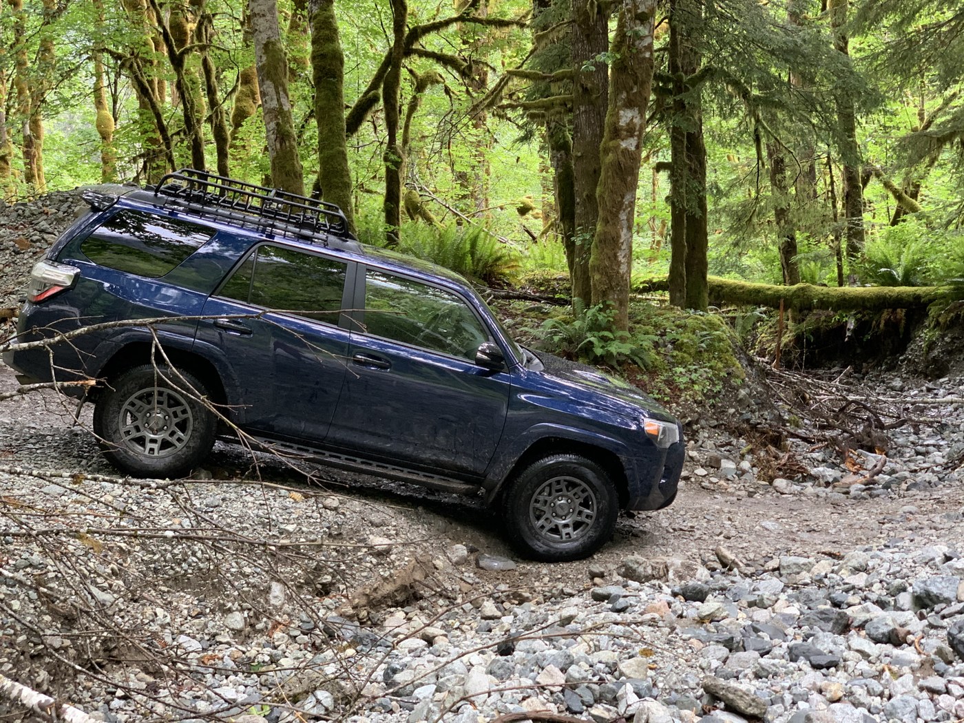 A high clearance vehicle drives down a dip on a very rocky road