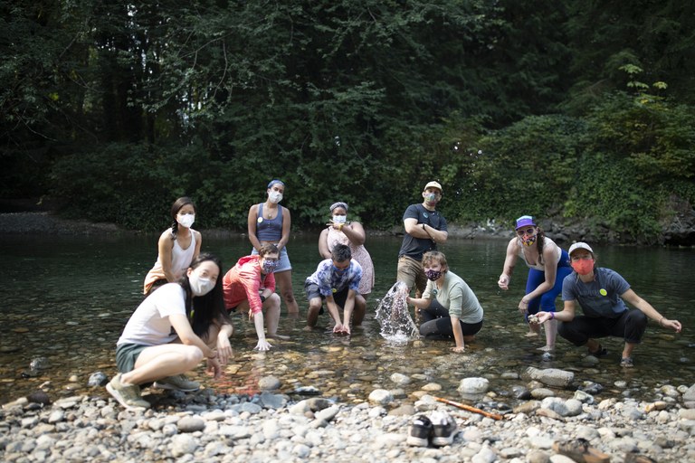 A group of Sea Potential participants gather on a rocky shore.