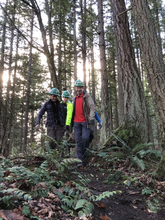 Volunteers carrying a rock at Sehome Arboretum