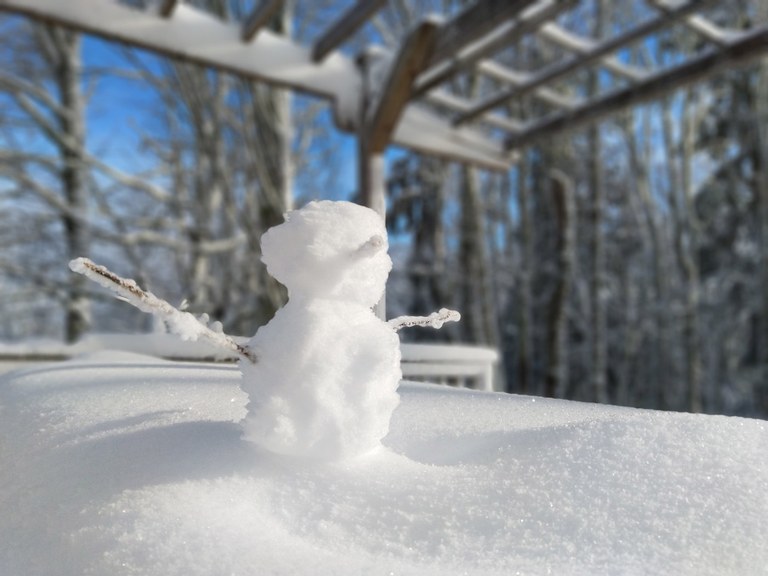 Shangri La. Cascade Yeti. A small snowman on a snow-covered picnic table along a hiking trail.