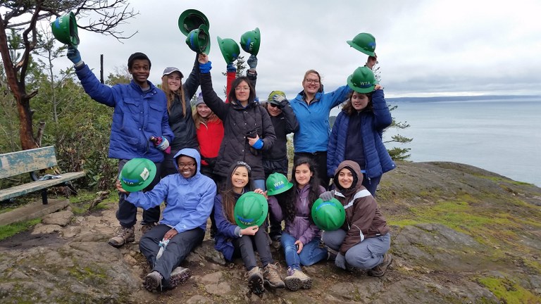 A group of young volunteers show off their green hats at a trail work party. Photo by Barbara B. 