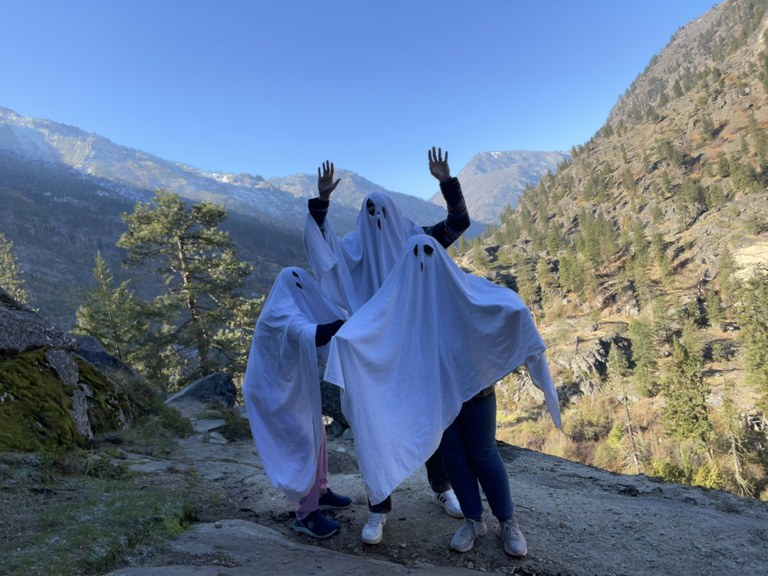 3 hikers dressed as ghosts at a viewpoint on the Snow Lakes trail in the Enchantments. Photo by TrailKat.
