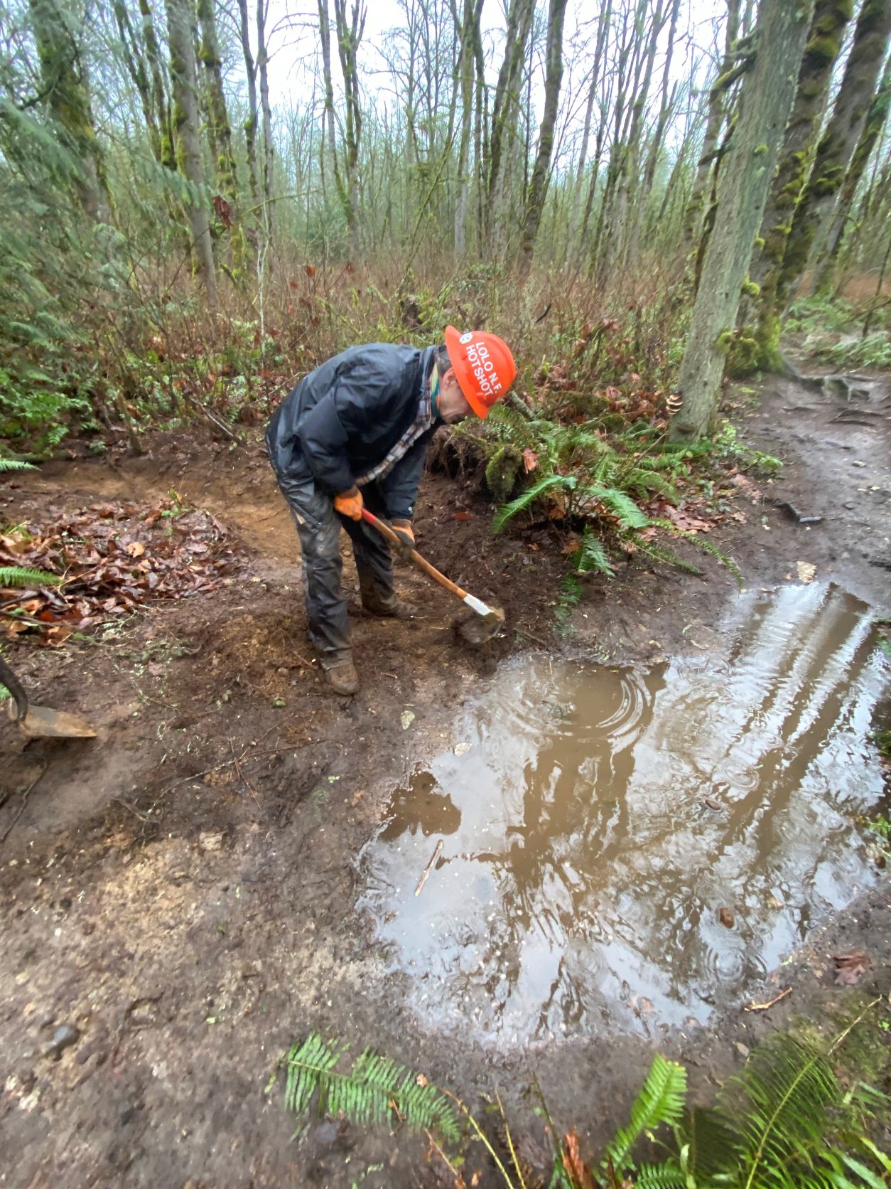Soaring Eagle Regional Park. Photo by Emily Snyder. Volunteer digging a new drain next to a large muddy puddle on a trail at Soaring Eagle Regional Park. Photo by Emily Snyder.
