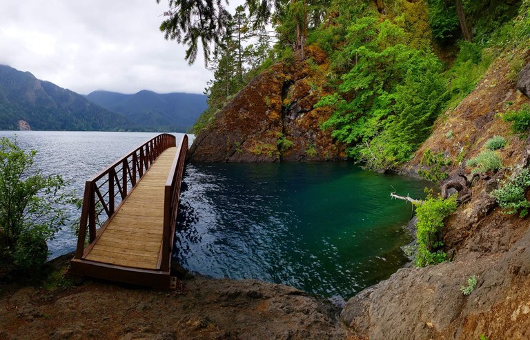 Spruce Railroad Trail. Photo by Marissa Edwards. A bridge crosses over an aquamarine inlet on the shore of Lake Crescent. Photo by Marissa Edwards.