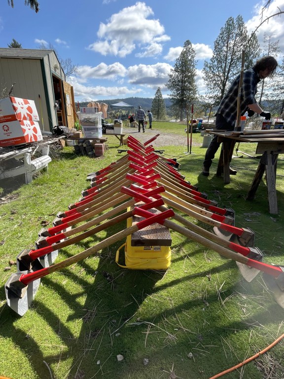 tool work2 Holly Weiler.JPG trail work tools lined up with their red handles together.