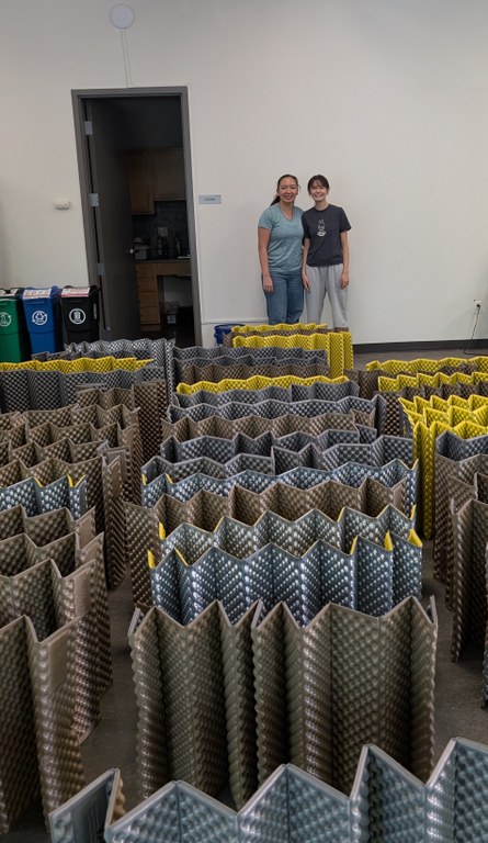 Scouts pose behind all the sleeping pads they cleaned.