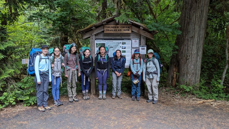 A group of Girl Scouts with backpacking gear, ready to hike.