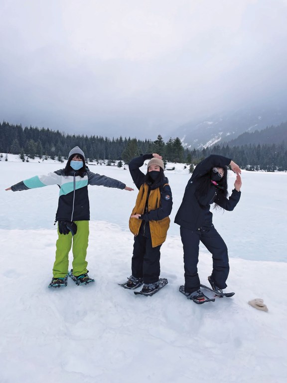 Participants dressed in cold-weather gear and snowshoes spell the letter tSB with their arms.