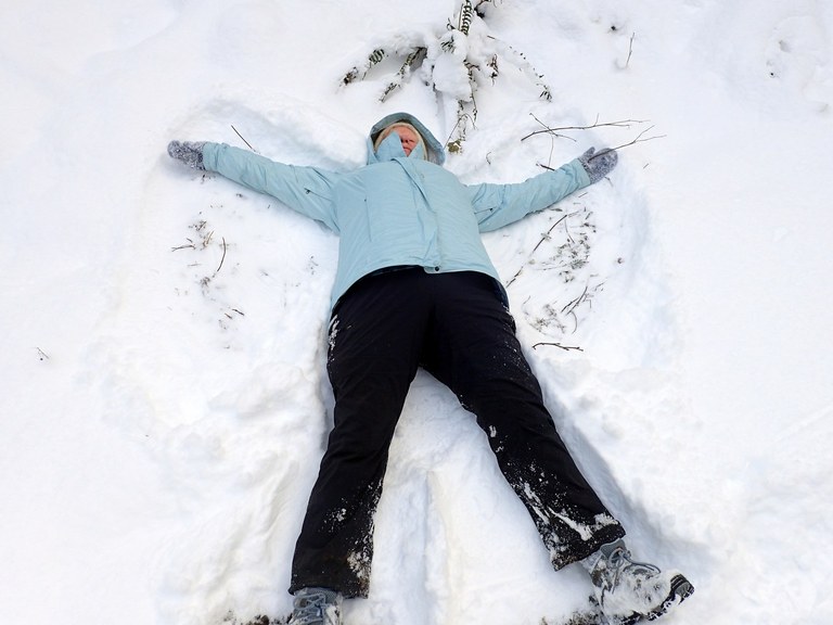 Ueland Tree Farm. Photo by RideDive. A person lays in the snow making a snow angel.