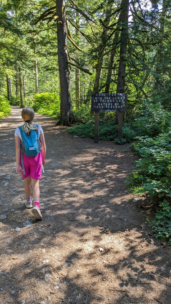 A young hiker walks past the Wordsworth quote sign at Wallace Falls. Photo by karacmomof3. 