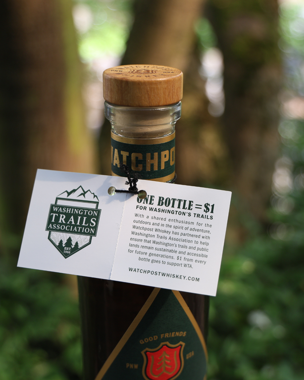For every bottle of Watchpost sold, Westland Distillery is donating $1 to WTA. Photo by Victoria Obermeyer. A tag featuring WTA's logo on a bottle of whiskey with a green and red label. Photo by Victoria Obermeyer.