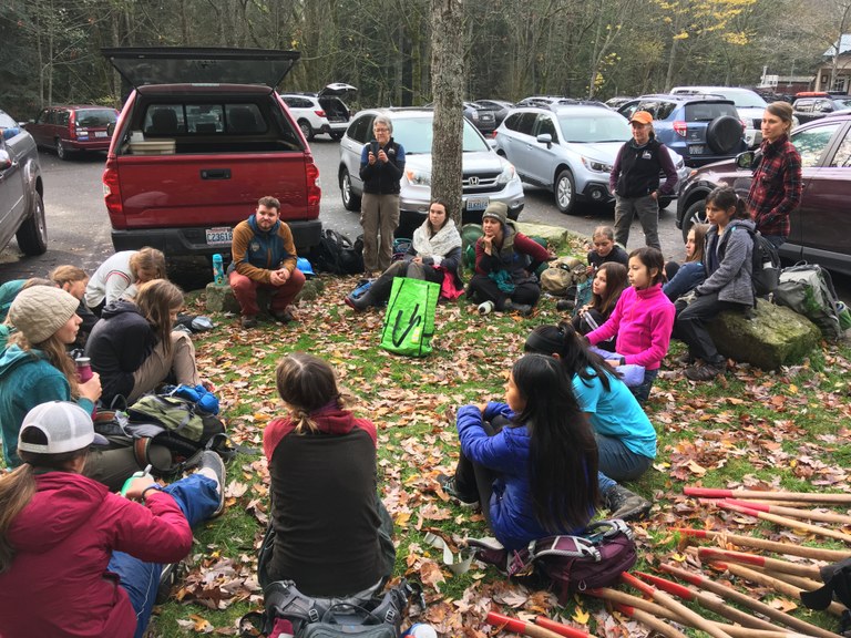 WTA leaders and Wild Whatcom participants sit in a closing circle after a day of trail work.