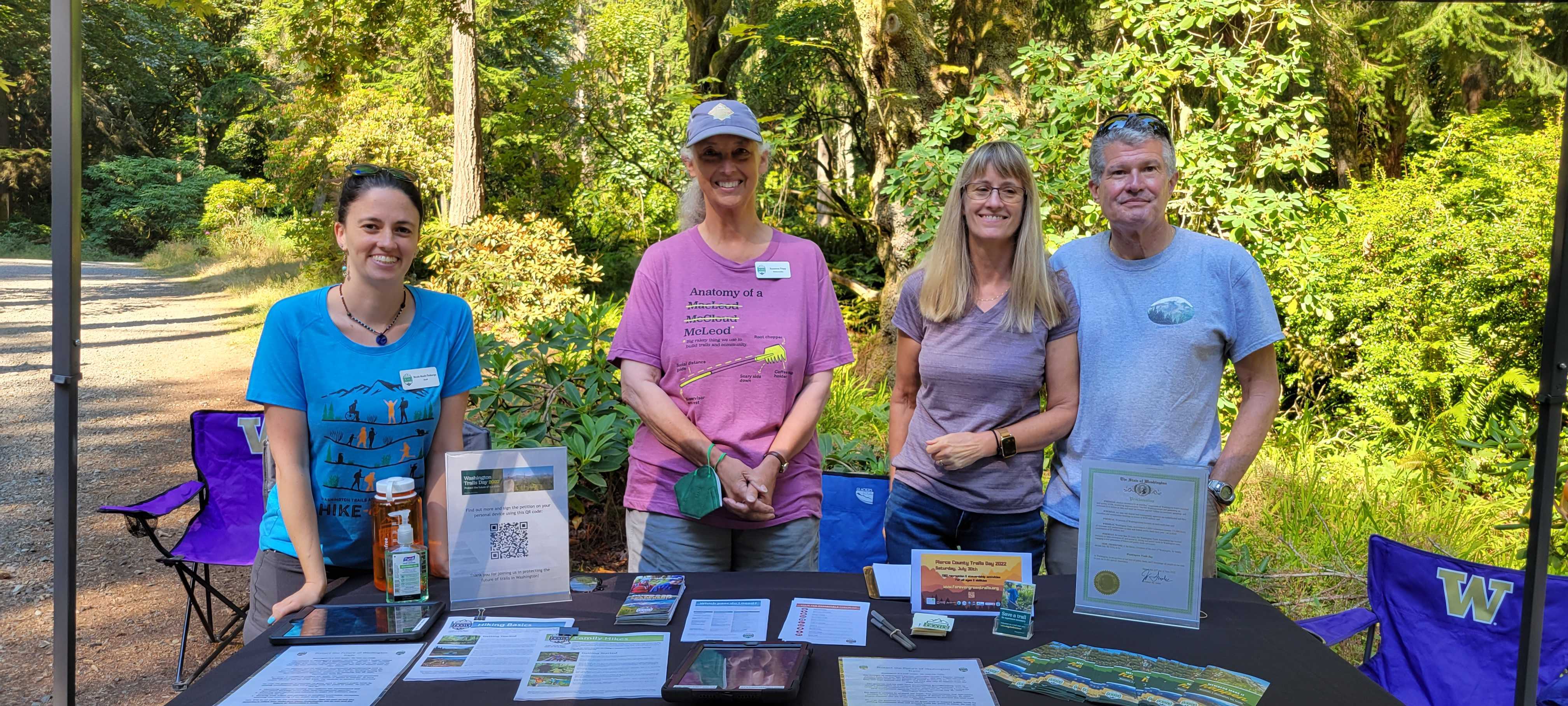 Volunteers smile at their outreach table at Point Defiance.