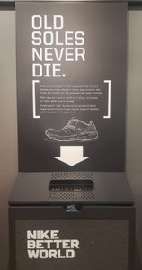 A gray box with an outline of a sneaker encouraging people to leave old shoes in it.