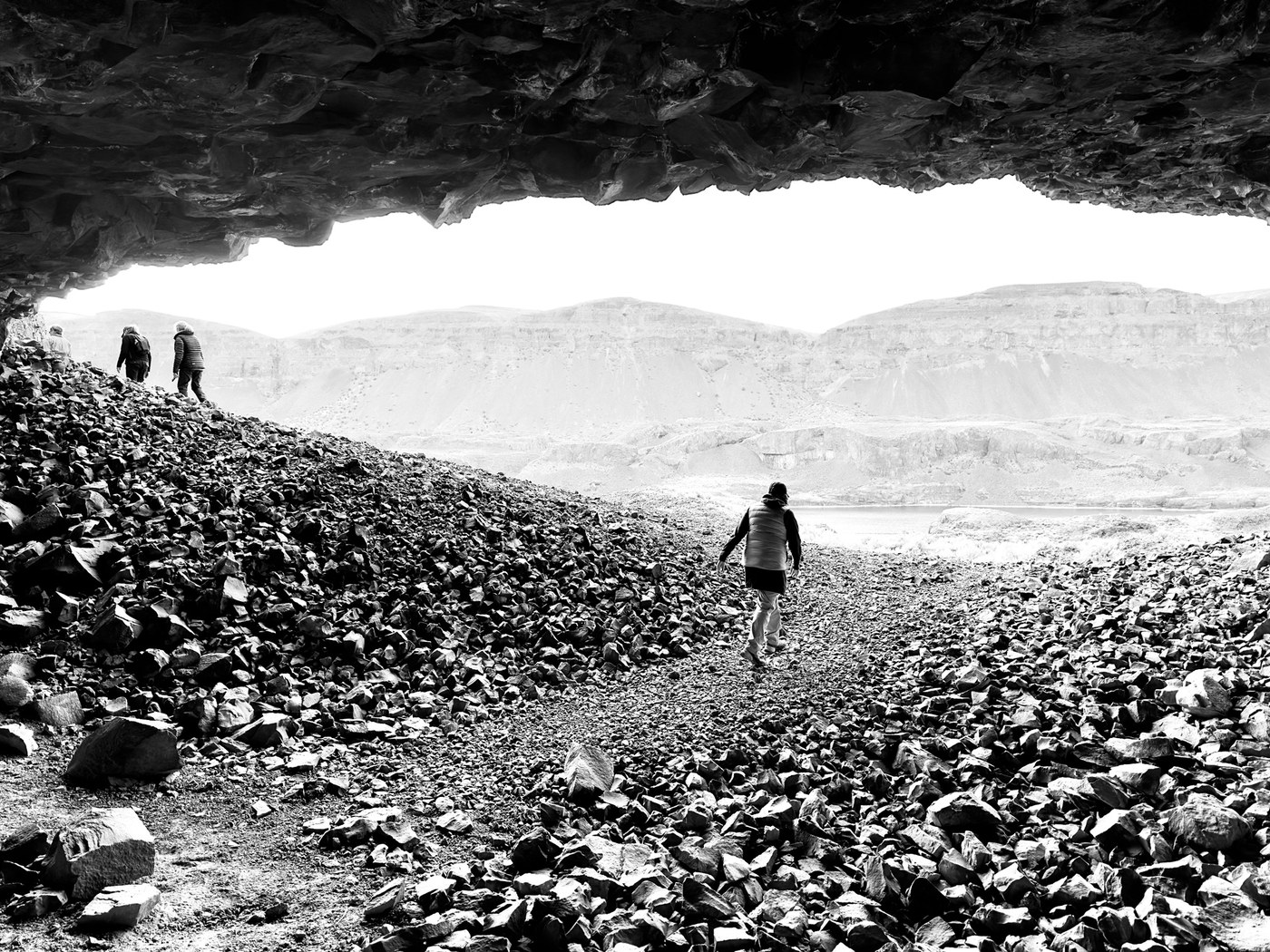 Lenore Lake Caves. Photo by The path before you. Hikers exploring the Lenore Lake Caves, a black and white photo. Photo by The path before you.